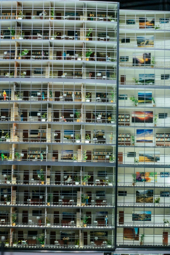 Detailed multi-level miniature office building, representing interconnected teams, signals and operations.